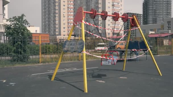 Leerer Spielplatz während der Coronavirus-Pandemie. Warnbänder auf den Fahrgeschäften — Stockvideo