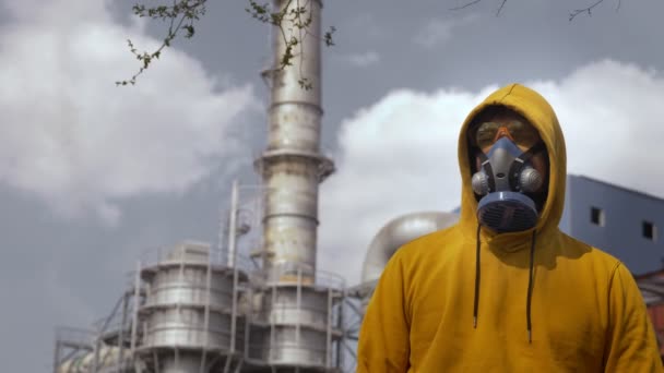 Hombre en respirador contra el fondo de las chimeneas de fábrica — Vídeo de stock