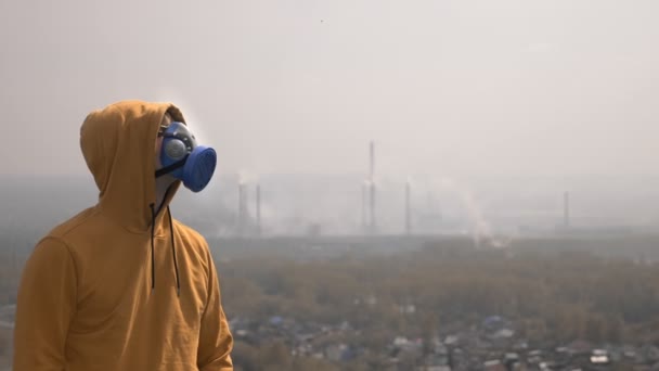 Homme dans un respirateur à l'extérieur sur fond de smog. espace de copie — Video