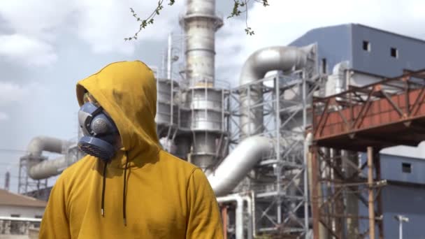 Man in respirator against the background of factory chimneys — Stock Video