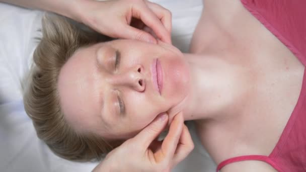 Massör ger kvinna anti-aging ansiktsmassage i spa — Stockvideo