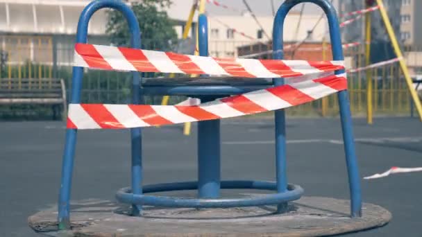 Leerer Spielplatz während der Coronavirus-Pandemie. Warnbänder auf den Fahrgeschäften — Stockvideo