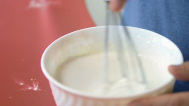 Yakın plan. Bir adam un ile yumurta çırpar. Ev mutfağında tatlı yap.