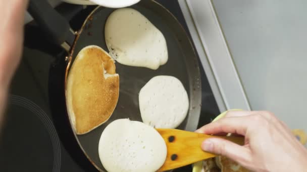 Verticaal. close-up, iemand kookt pannenkoeken in een pan op een fornuis aanraking — Stockvideo