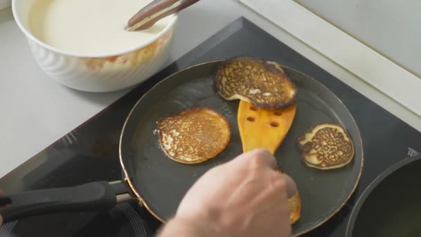 Κοντά, κάποιος μαγειρεύει τηγανίτες σε ένα τηγάνι σε μια κουζίνα αφής — Αρχείο Βίντεο