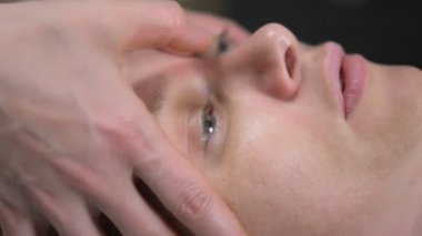 Masör kaplıcada kadınlara yaşlanma karşıtı yüz masajı yapıyor.