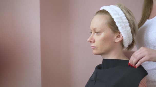 Ο στυλίστας διεξάγει μια διαδικασία τύπου χρώματος για μια γυναίκα — Αρχείο Βίντεο