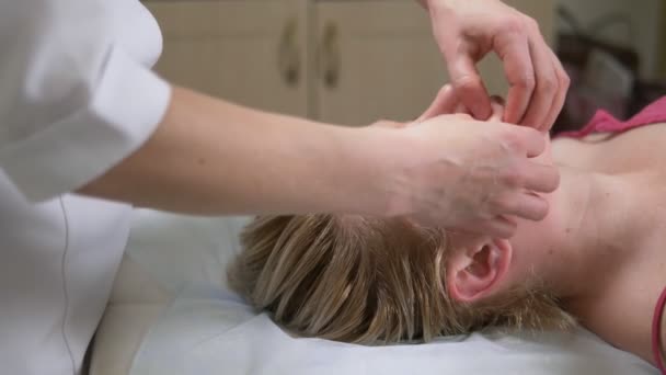 Massagista dá mulher anti-envelhecimento massagem facial no spa — Vídeo de Stock