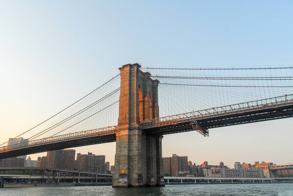 Brooklyn Bridge against the New York skyline at sunset
