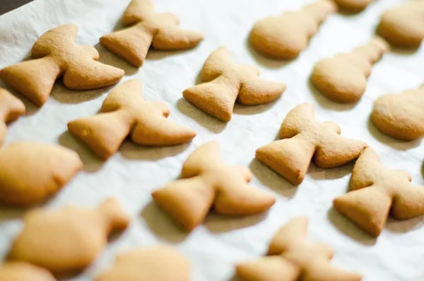 Ensemble de biscuits en forme de thème de Noël sur fond de papier de cuisson blanc. Ange, bonhomme de neige et poisson — Photo