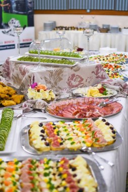 Buffet table full of food in small dishes, sweets and a fruit platter. clipart