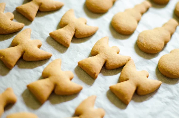 Ensemble de biscuits en forme de thème de Noël sur fond de papier de cuisson blanc. Ange, bonhomme de neige et poisson — Photo