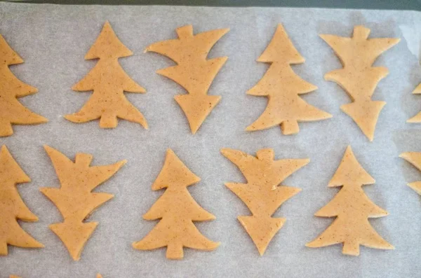 Biscuits en forme d'arbre de Noël sur fond de papier de cuisson blanc — Photo