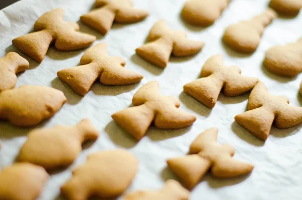 Ensemble de biscuits en forme de thème de Noël sur fond de papier de cuisson blanc. Ange, bonhomme de neige et poisson — Photo