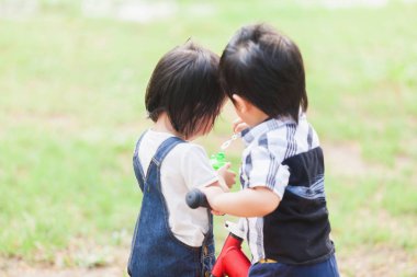 Cute 2-3 yıl eski iskambil kabarcık bahçedeki çocuklar