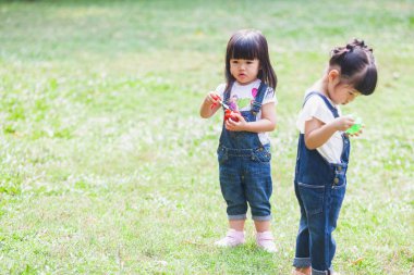 Cute 2-3 yıl eski iskambil kabarcık bahçedeki çocuklar