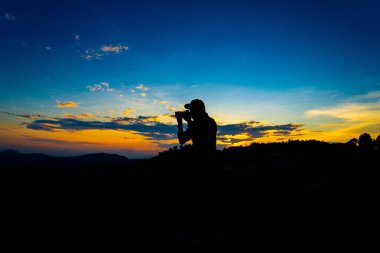Siluet Adam Tepede Kamerayla Duruyor Dağ 'da Sunset' te Blue Sky ile. Huzur Anı Kavramı 'nın tadını çıkarıyorum. Rahatlatıcı ya da başarı kavramı.