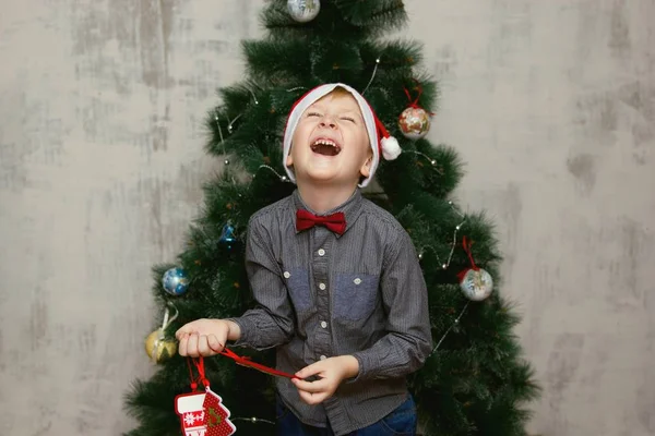 Маленький хлопчик позують з аксесуари Xmas перед Xmas дерево — стокове фото