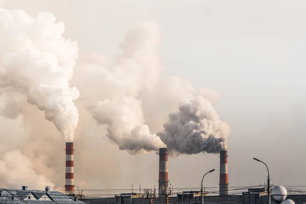 Industriella skorstenar med tung rök orsakar luftföroreningar på grå himmel bakgrund — Stockfoto