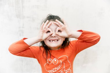 Gülümseyen mutlu dişsiz kızın portresi beyaz arka planda süt dişlerini düşürdü.