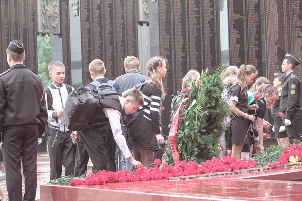 Khabarovsk, Ryssland - 09.02.2016: Studerande sätter blommor till minne av evig låga tillägnad minnet av världskrigets deltagare — Stockfoto