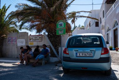 Perissa, Greece - July 18 2019:   Passengers waiting for a bus on the Fira to Perissa Road