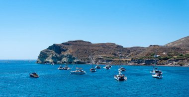 Akrotiri, Yunanistan - 19 Temmuz 2019: Tekneler Ege 'nin Akrotiri kızıl plajındaki körfezde toplandı