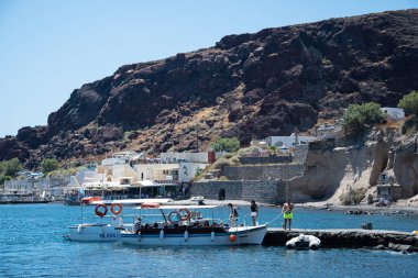 Akrotiri, Yunanistan - 19 Temmuz 2019: Turistler Akrotiri limanında küçük bir tur teknesine biniyorlar