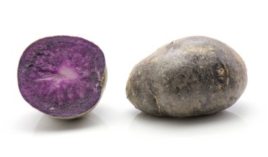 Vitelotte patates üzerinde beyaz izole arka plan bir bütün ve bir dilimlenmiş hal