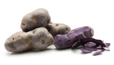 Bir soyulmuş vitelotte patates ve üç soyulmamış izole üzerinde beyaz arka plan purpl