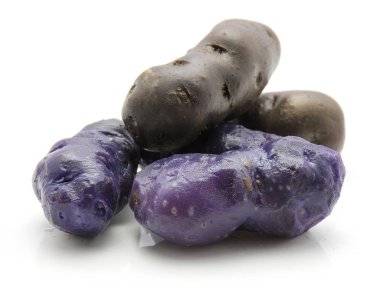 Haşlanmış vitelotte patates beyaz arka plan üzerinde üç soyulmuş ve iki tüm purpl izole