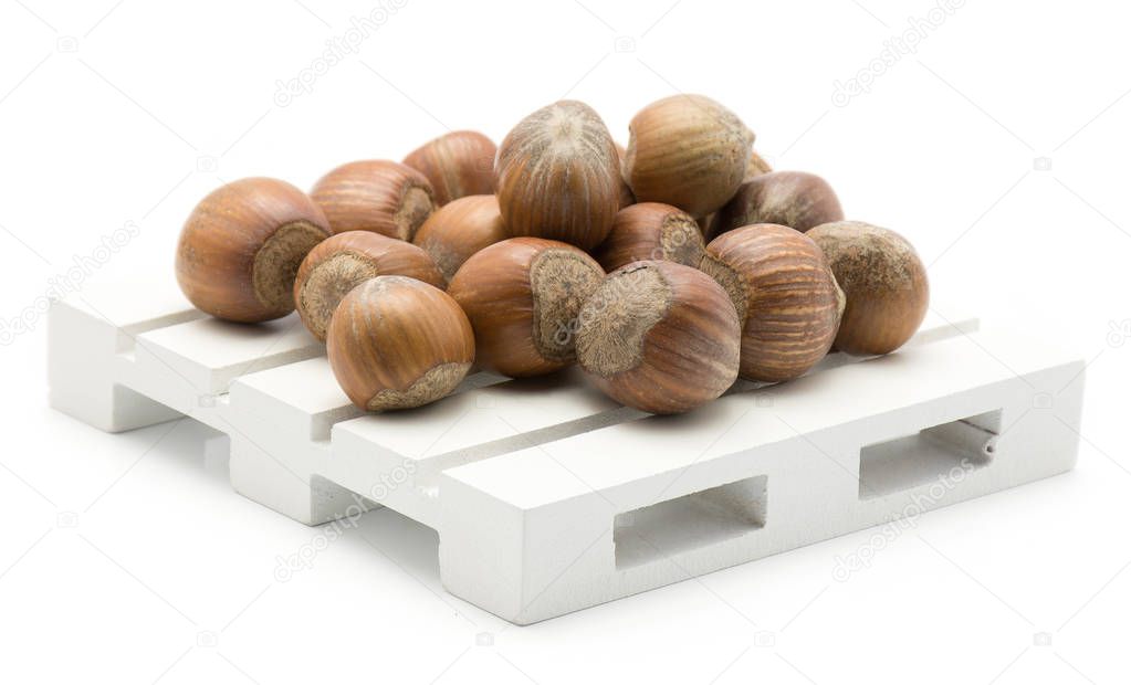 Hazelnuts unshelled on a pallet isolated on white backgroun