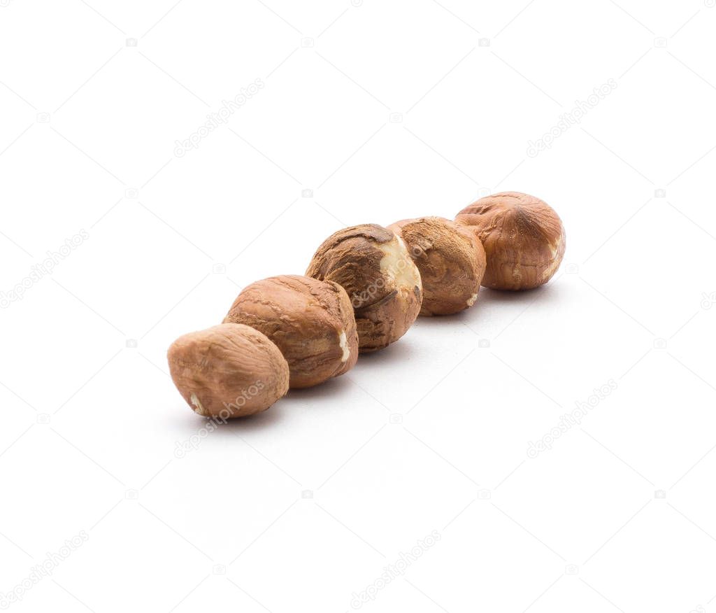 Shelled hazelnuts isolated on white background five brown whole in ro