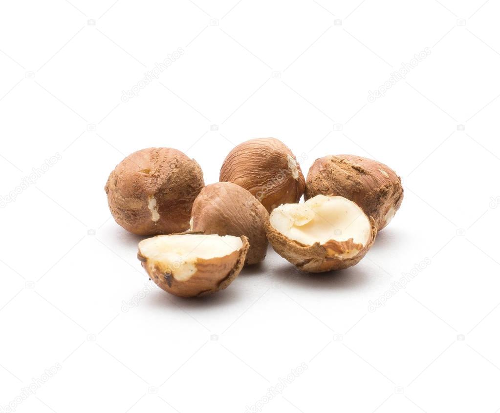 Shelled hazelnuts one nut cut in half isolated on white backgroun