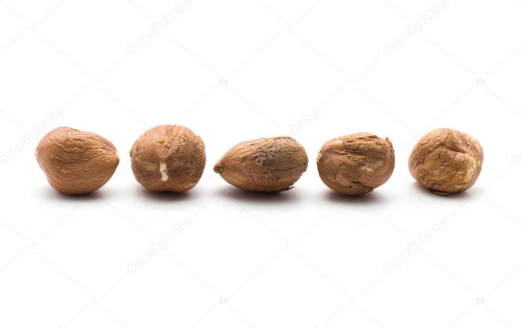 Five shelled hazelnuts in row isolated on white backgroun
