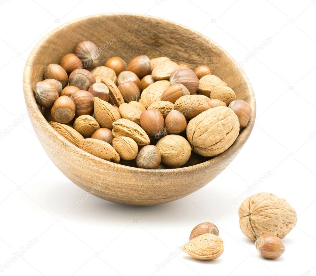 Nuts mix (walnut, hazelnut and almond) in a wooden bowl isolated on white backgroun
