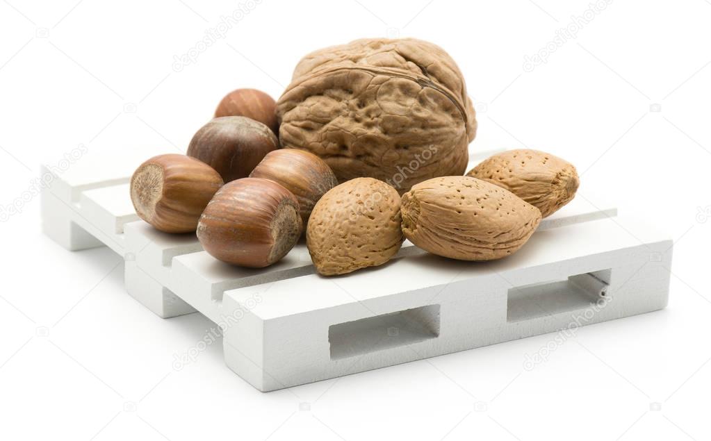 Nuts mix (walnut, hazelnut and almond) on a pallet isolated on white backgroun