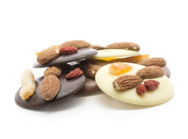 İki badem, ananas ve berry, üzerinde beyaz adam izole ile eritilmiş çikolata daireler yığını (karanlık, sütlü ve beyaz çeşitleri)