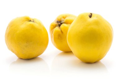 Üç sarı beyaz arka plan üzerinde ham izole ayvaları Olgun