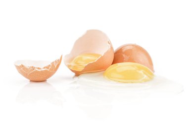 Beyaz arka plan üç kırık yumurta kabuğu parçası üzerinde izole kahverengi tavuk yumurta iki ham sarısı kırık