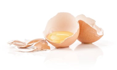 Bir çiğ yumurta sarısı kahverengi tavuk yumurta kabuğu iki yarısı kırık parçalar üzerinde beyaz adam izole bir sürü