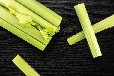 Taze yeşil kereviz ve üç stickler üzerinde siyah ahşap adam izole