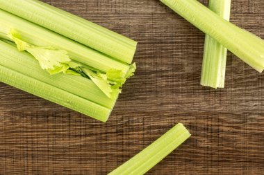 Üç stickler üzerinde ahşap adam izole bir taze yeşil kereviz