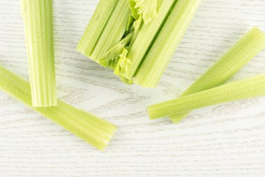 Dört sopa üzerinde hafif ahşap adam izole bir taze yeşil kereviz