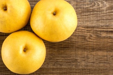 Çin altın armut üstten görünüm Nash'e çeşitli ahşap arka plan üzerinde üç bütün roun izole.