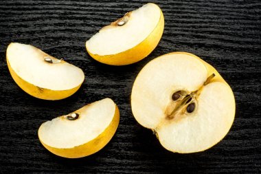 Çin altın armut top Nash'e çeşitli izole ahşap arka plan siyah bir kesit üzerinde yarısı görünümü üç dilim