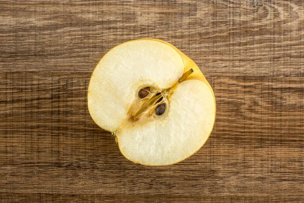 Chinese golden pear one section half top view Nashi variety isolated on wooden backgroun