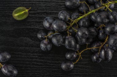 Siyah ahşap adam izole siyah üzüm (Sonbahar royal çeşitli) içeren kümeler bir dilimlenmiş berry masa üstü