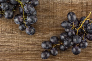 Üzerinde kahverengi ahşap adam izole siyah üzüm iki küme (Sonbahar royal çeşitli) masa üstü