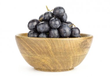 Siyah mor üzüm küme (Sonbahar royal çeşitli) üzerinde beyaz adam izole bir ahşap kase